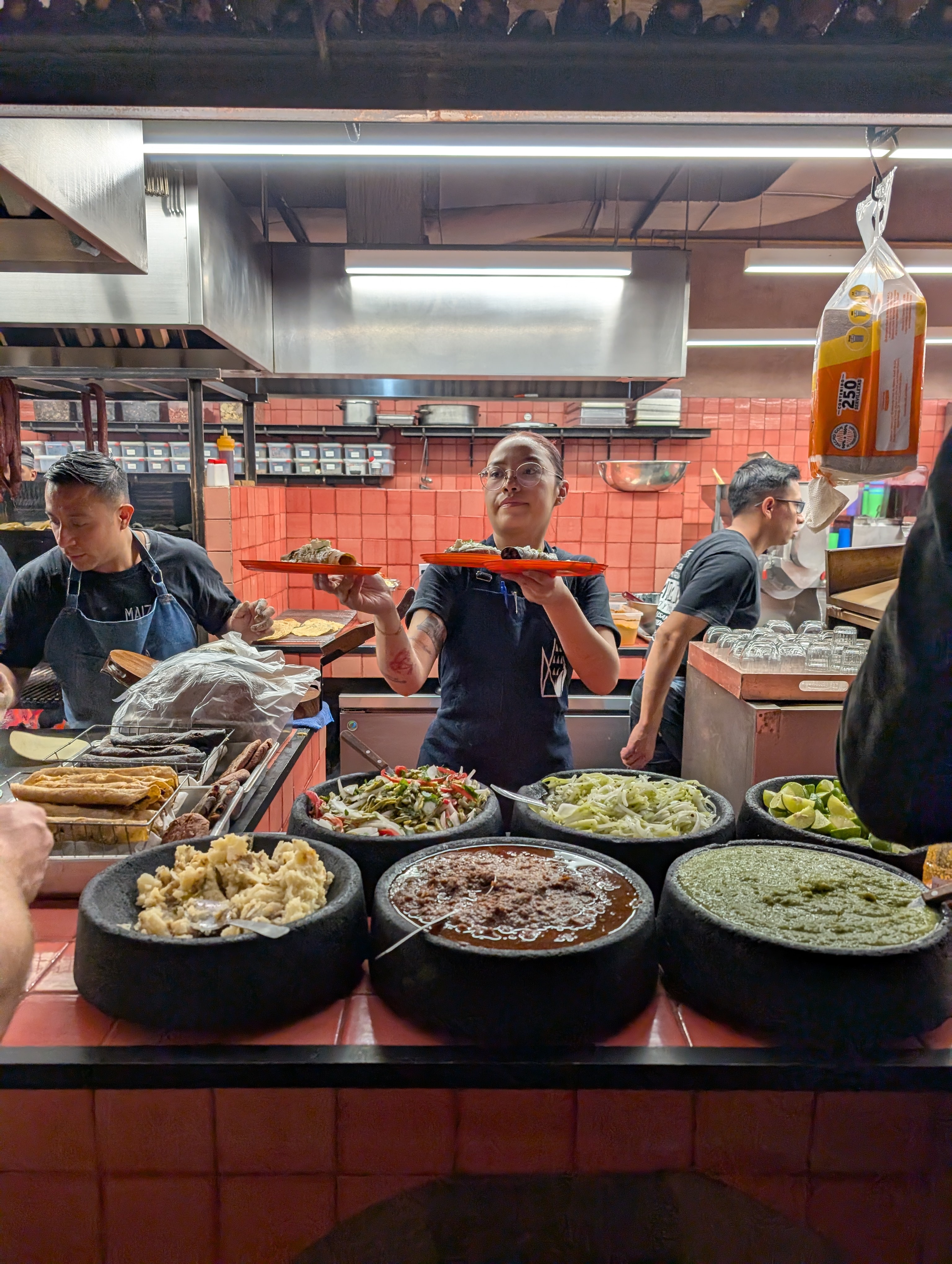 A server hands out tacos from Maizajo’s busy kitchen